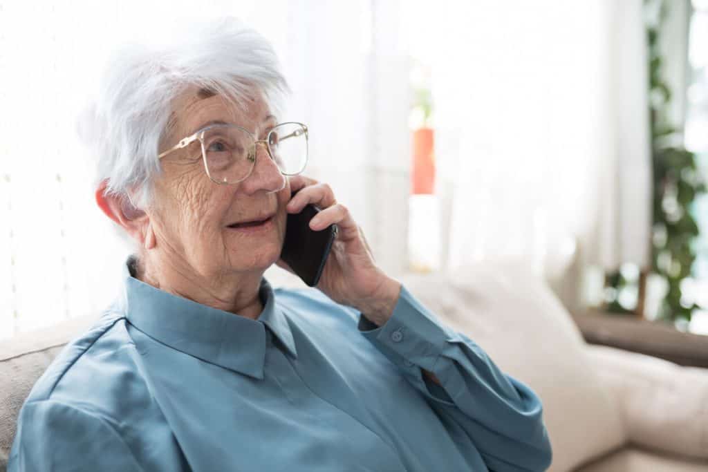 An elderly woman talking on the phone