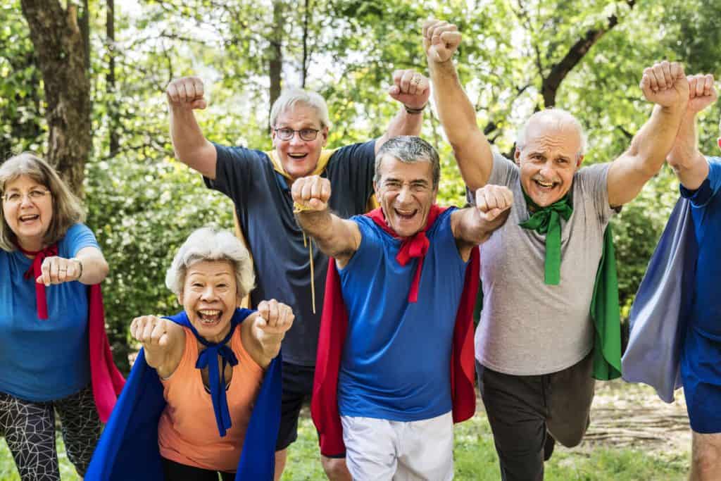 Happy seniors wearing superhero costumes