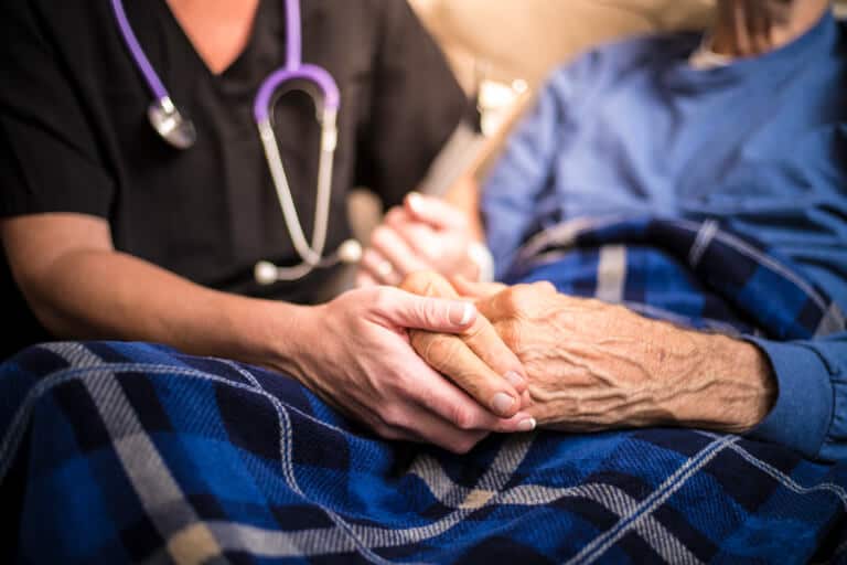 Palliative and hospice nurse providing care for a senior male patient