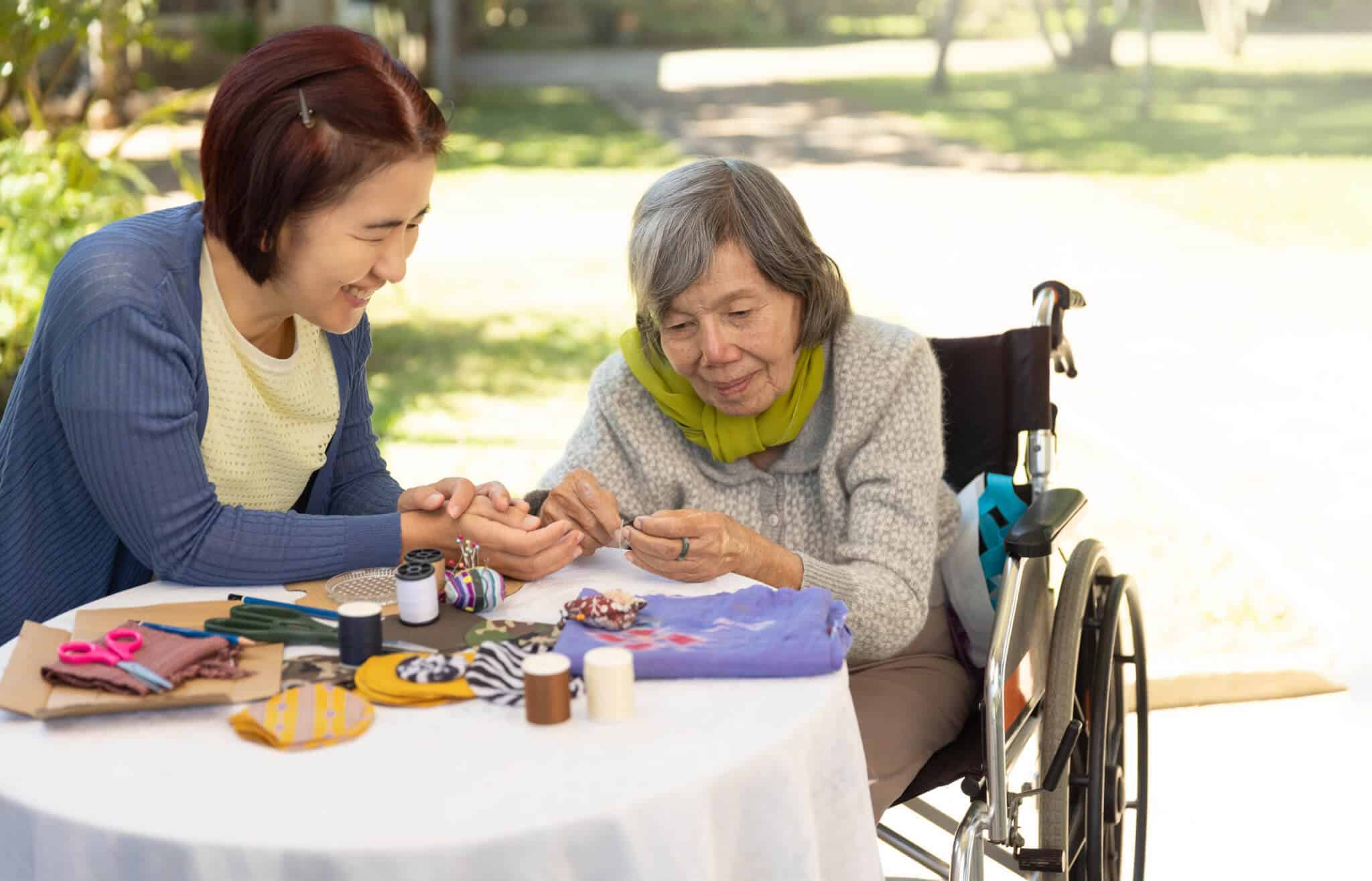 Senior participates in needle work during a social event