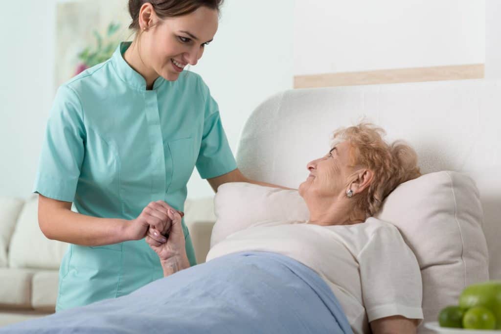 Senior woman in hospital with a female caregiver