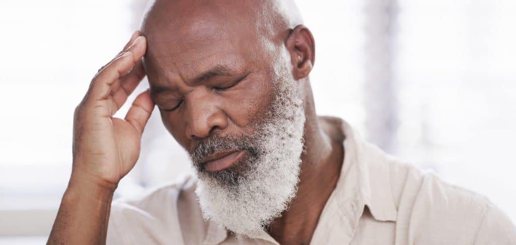 Senior man with white beard and his eyes closed in frustration, jobs sitting with elderly