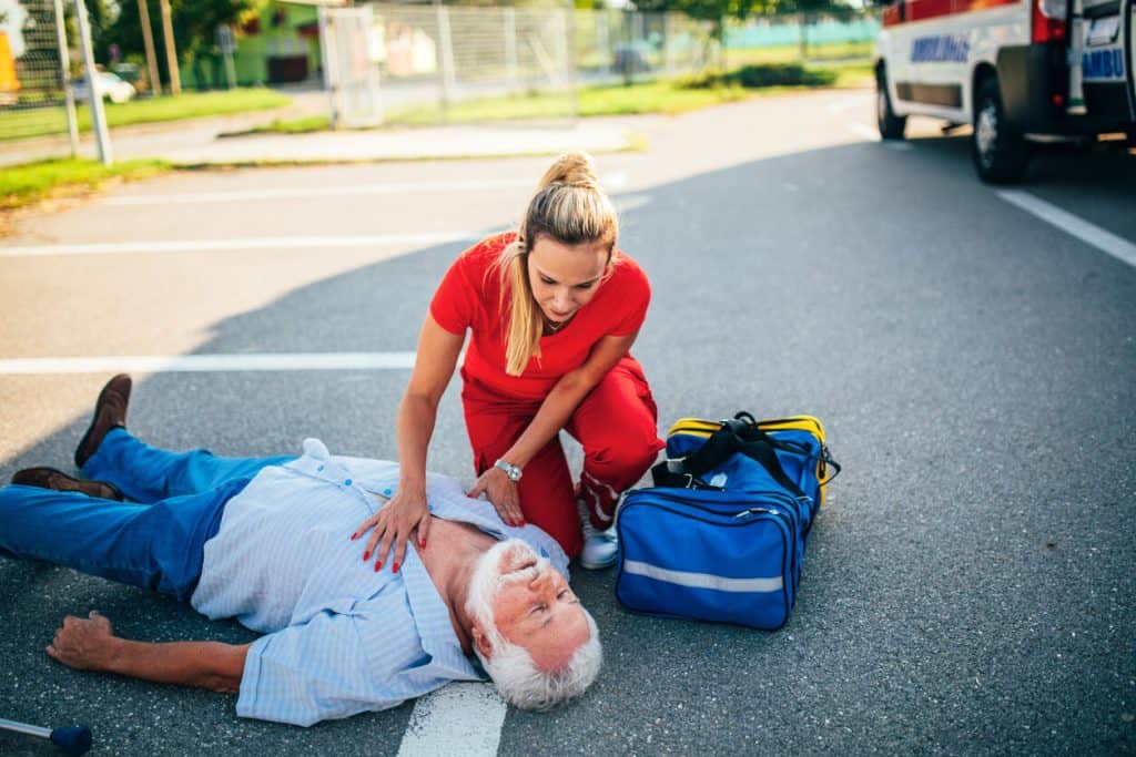 A caregiver is offering first aid to an older man, caregiver online course