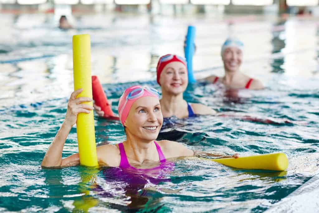 Three senior women in swimsuits doing water aerobics. unique activities for seniors