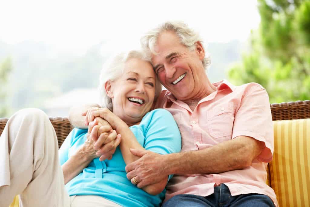 A senior couple sitting and laughing together. unique activities for seniors