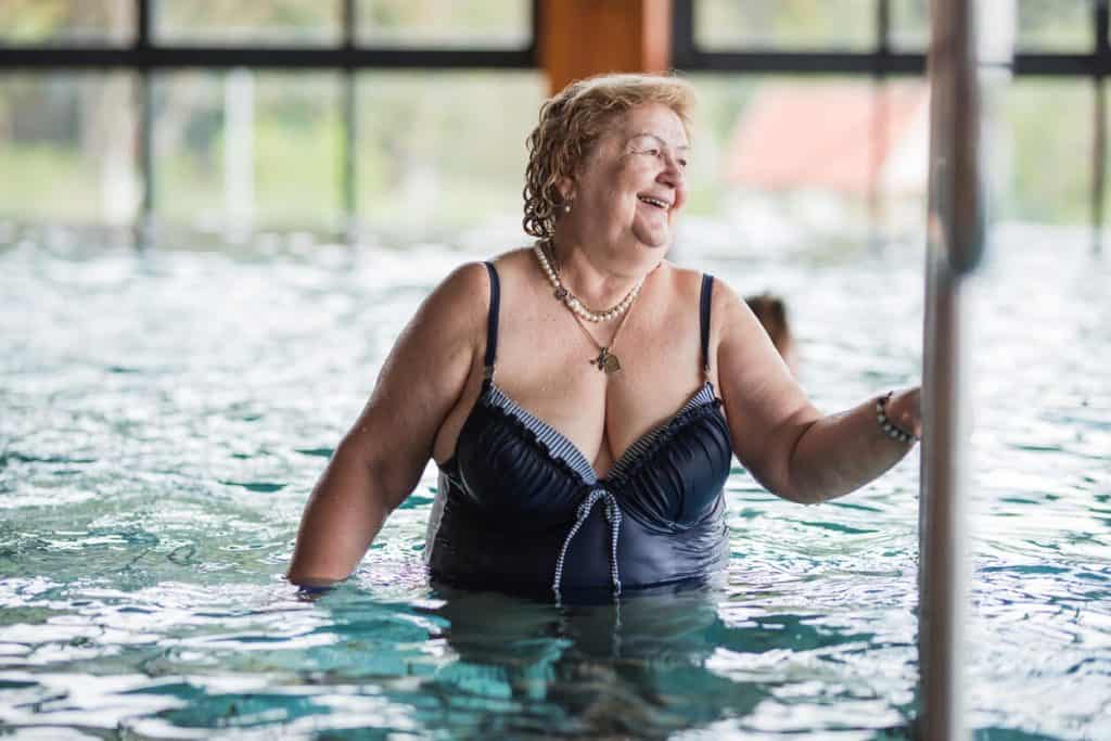an elderly woman enjoying the outdoors in a swimming pool. outdoor activities for seniors