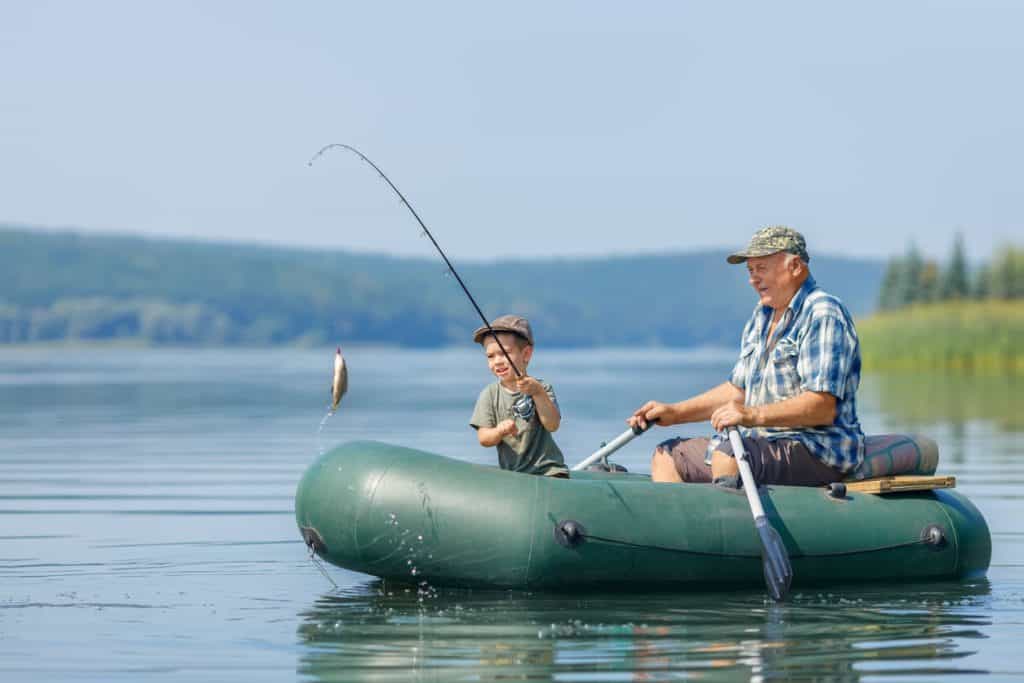 grandfather enjoying nature and teaching his grandson fishing. outdoor activities for seniors