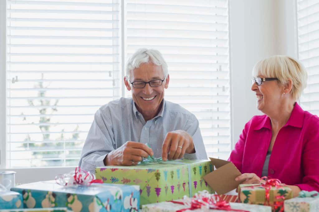 Seniors wrapping gifts in their assisted living facility, best activities for seniors in assisted living