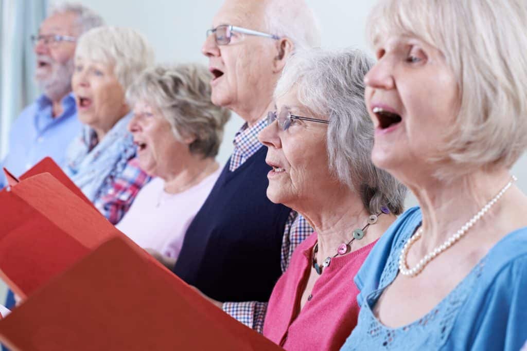A group of older people singing together, activities for seniors in assisted living facilities