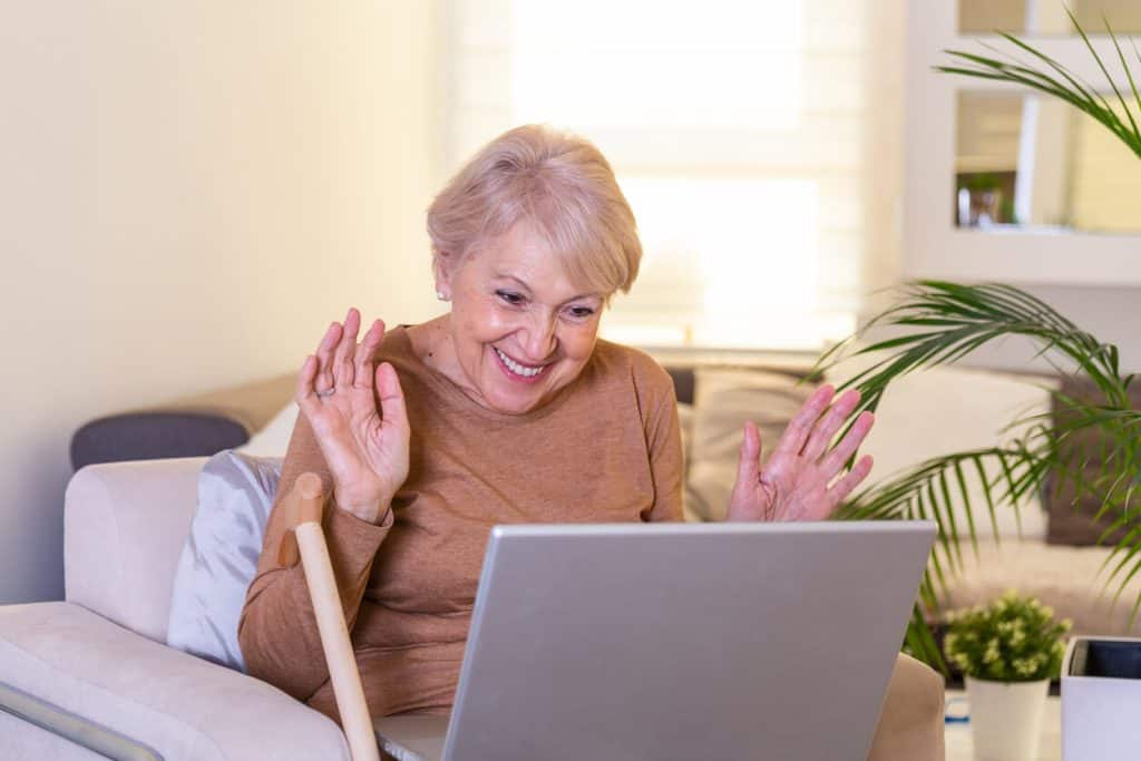 Senior woman at home talking to her family on skype - activities for seniors that live at home