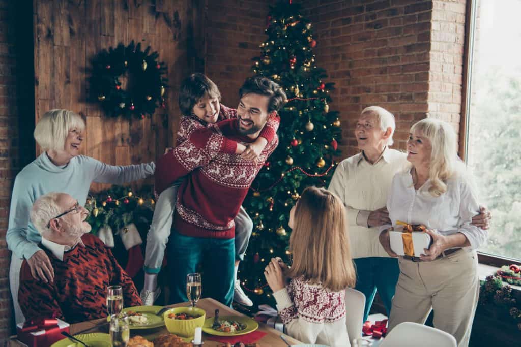 Senior couples with family celebrating Christmas traditions with decorations and December activities for seniors