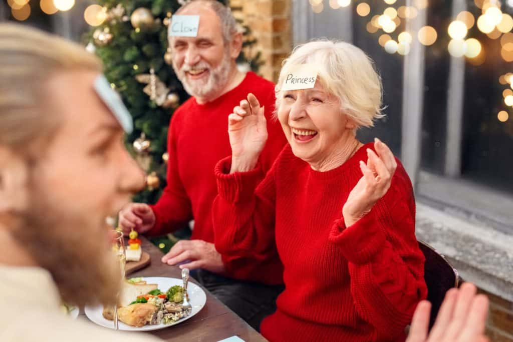 Two seniors playing a fun Christmas game at dinner. Christmas activities for seniors