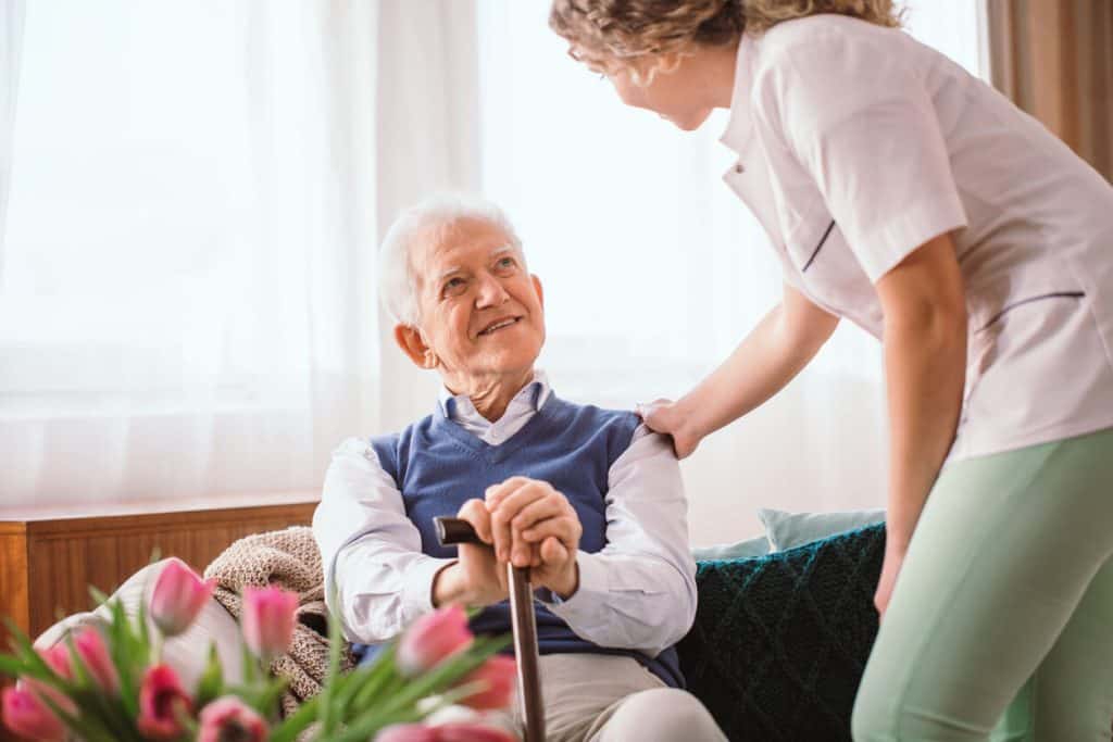 Caregiver gently talking to senior man with alzheimer’s activities for seniors with dementia