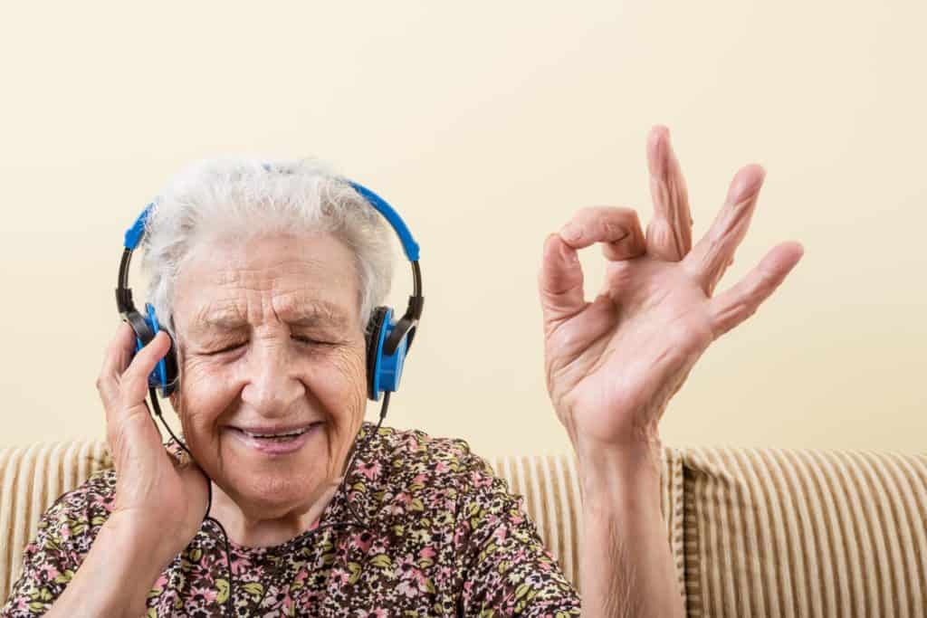 Elderly woman enjoying music through headphones indoor activities for seniors with dementia