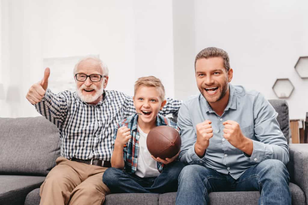 Senior man, his son, and grandson watching football on TV, activities for seniors with alzheimer’s