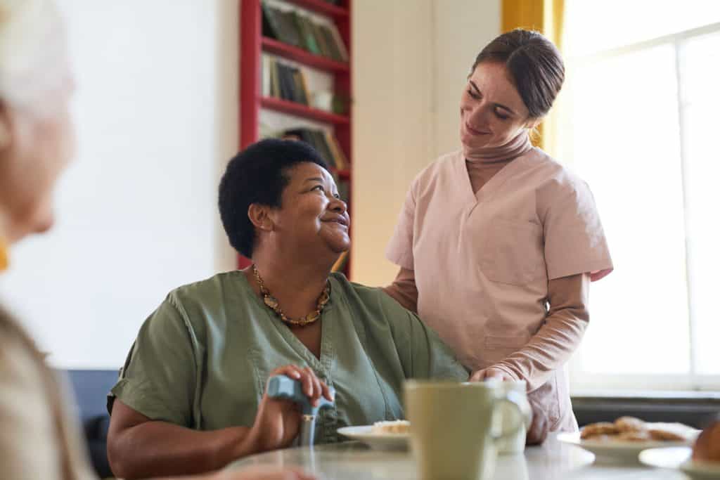 Elderly woman smiling at caregiver in a living community, assisted living in reno