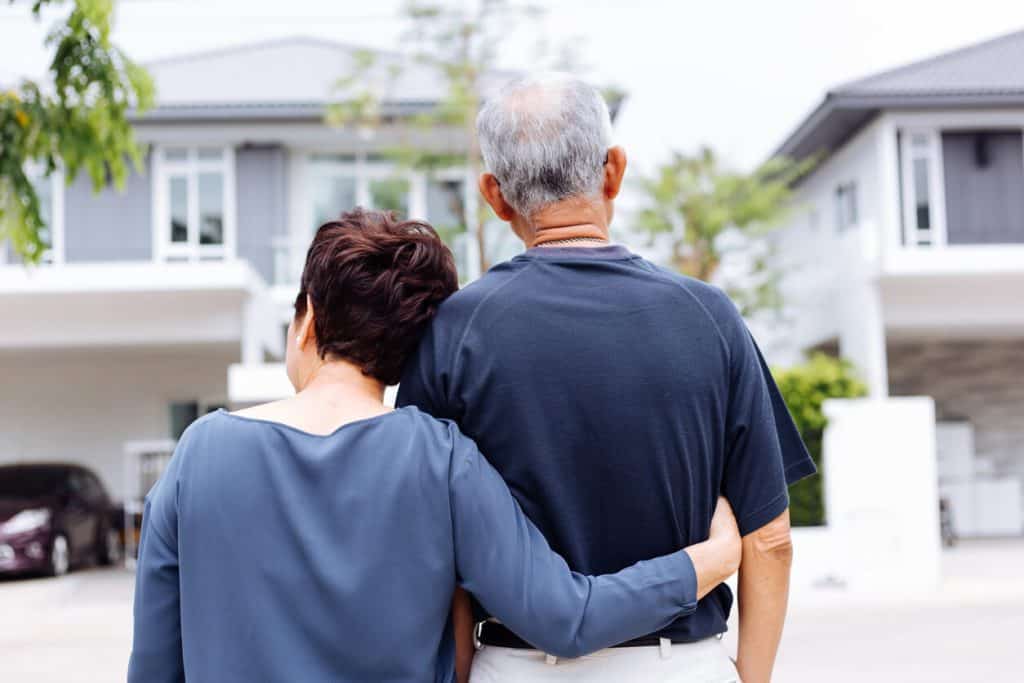 An elderly Couple gazing at a beautiful house, levels of care assisted living