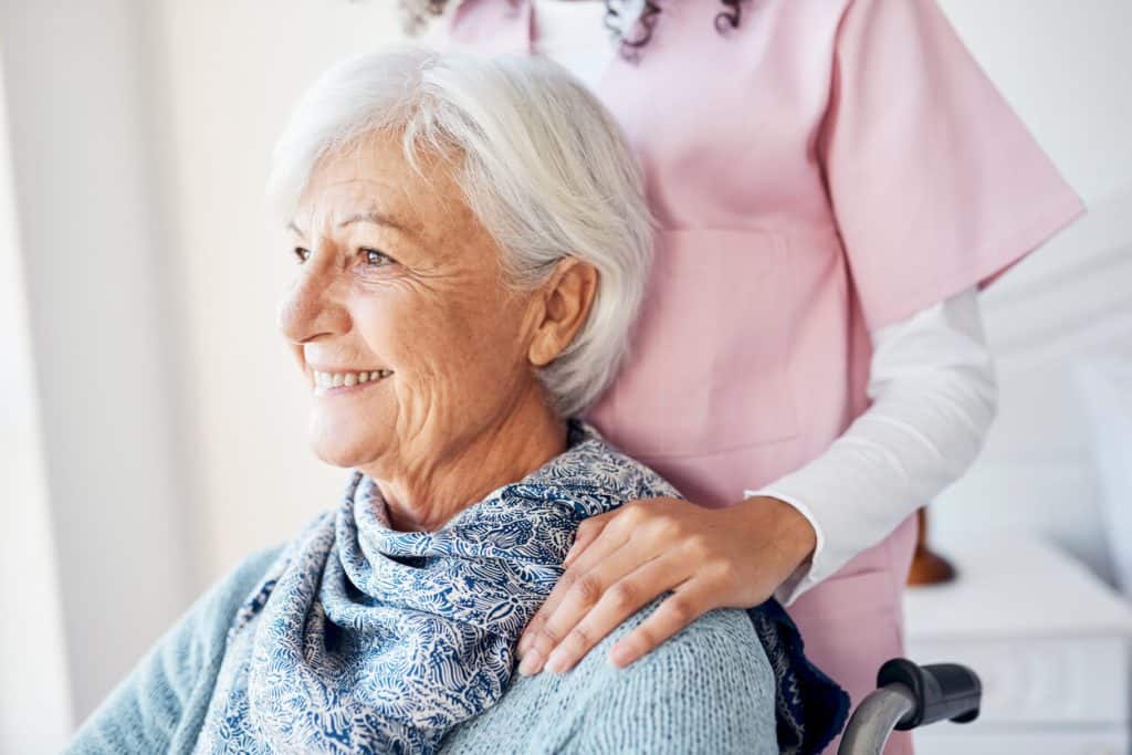 A smiling senior woman with her caregiver, assisted living with memory care