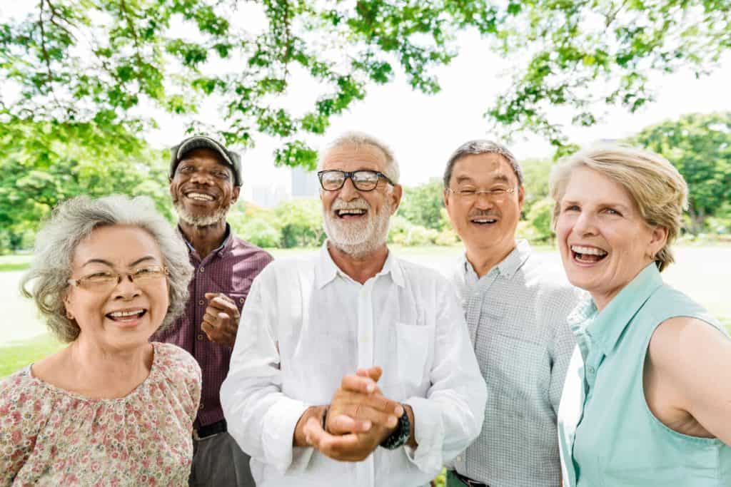 A group of seniors laughing together, assisted living with memory care