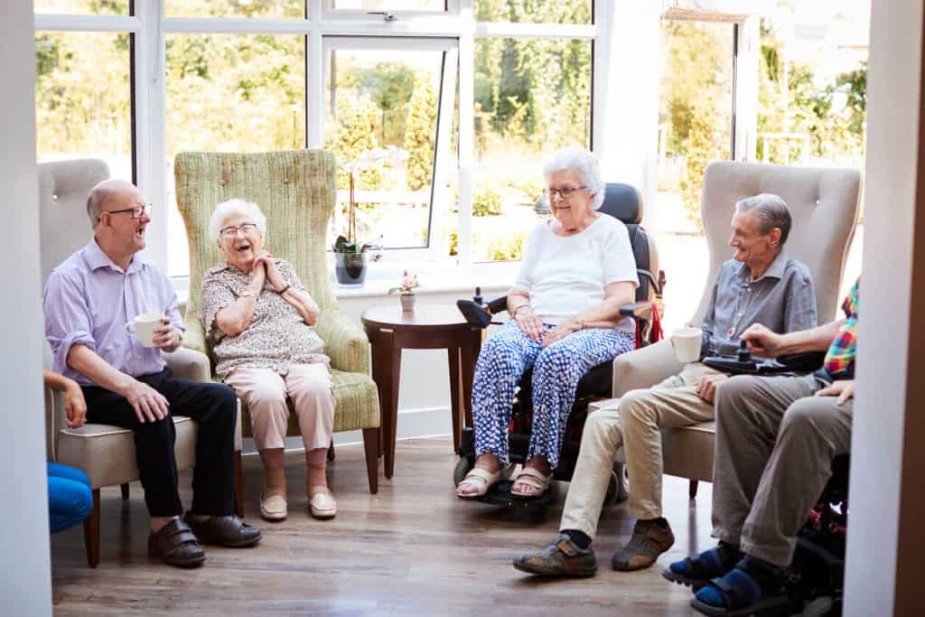 Seniors sitting and talking in a lounge at an assisted living community