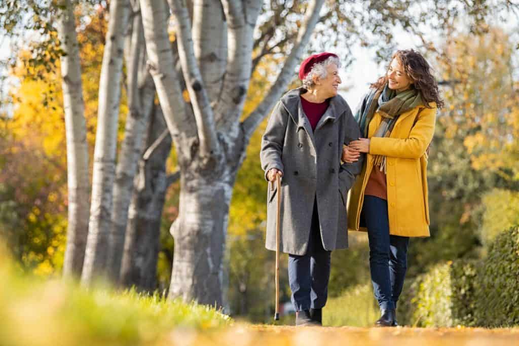 An elderly lady taking a walk with a companion, independence assisted living