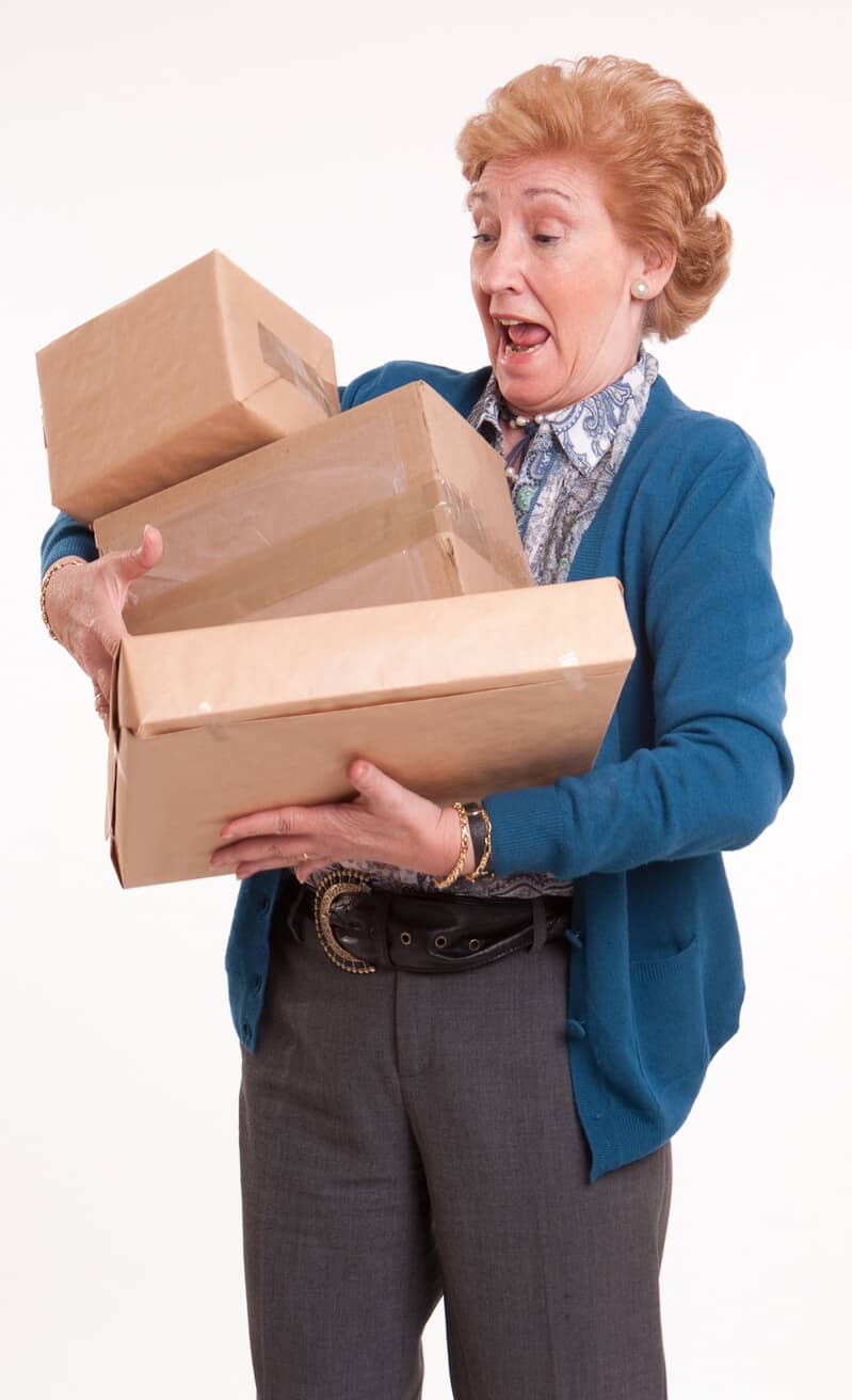 Senior woman with packed boxes alarmed and in shock, moving into assisted living checklis