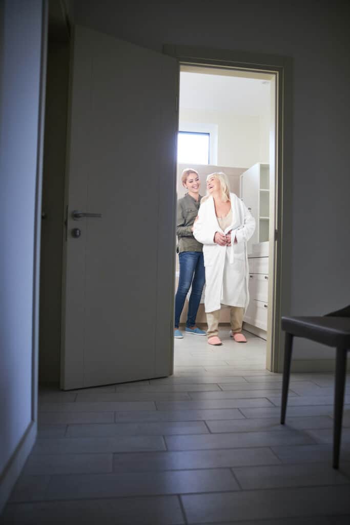 a young caregiver offering shower assistance to an older adult