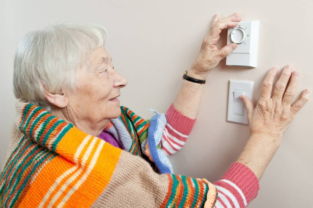 why are the elderly always cold | woman feeling cold adjusting temperature