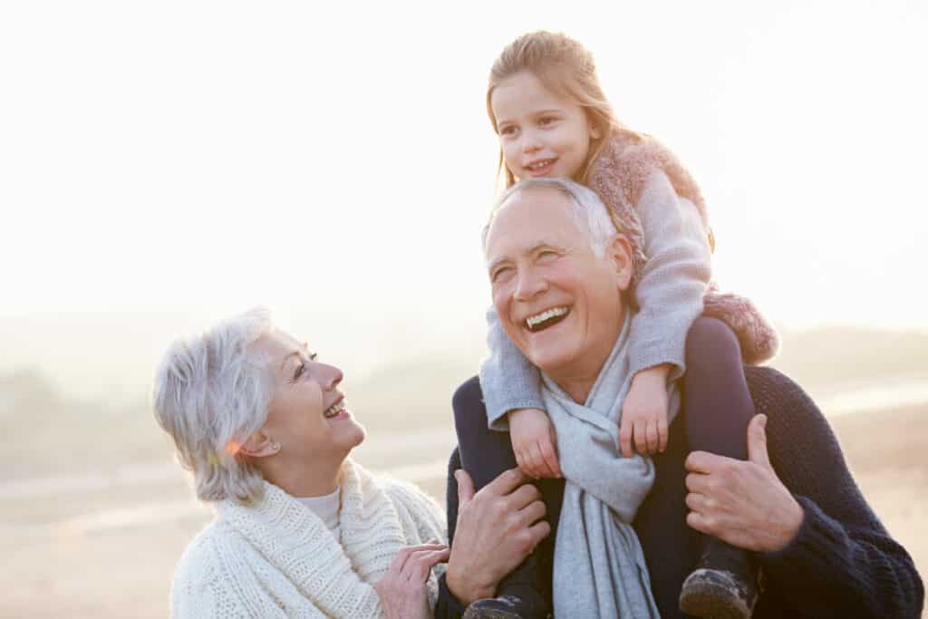 Grandparents spending time with a child. Grandmother's eyes look up at the child on grandfather’s shoulders. | herbs for eyesight