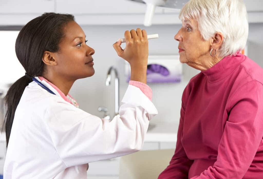 An eye exam with an eye doctor and an elderly lady.
