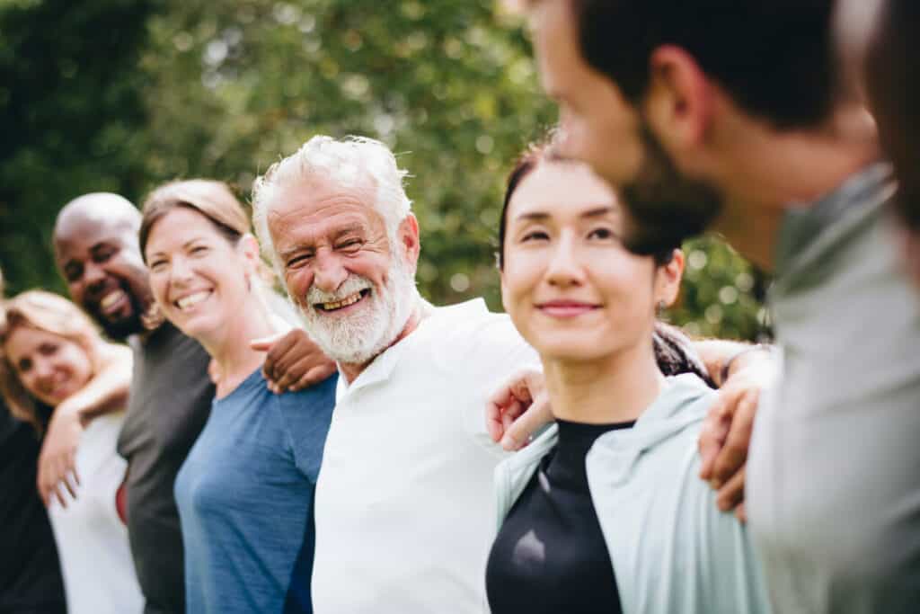 Group of seniors socializing in a park, which can help overcome symptoms of squalor disorder