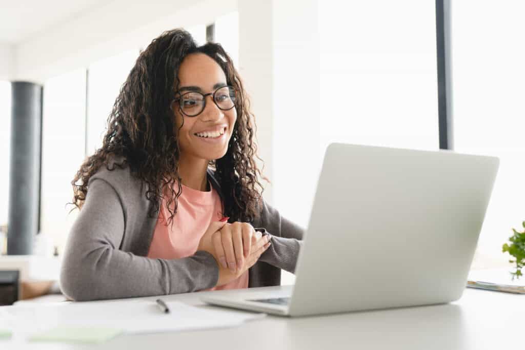 A smiling young Black woman taking caregiver classes online.