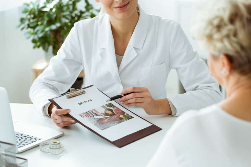 A photo of a female patient with nutrition questions to ask her female dietician about a personalized meal plan for diabetes.
