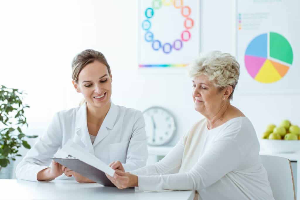 A female senior client thinking what to ask a nutritionist about her weight-loss diet plan.