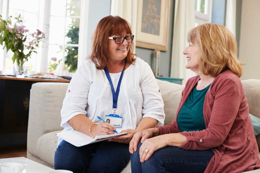 Female social worker with elderly woman at home