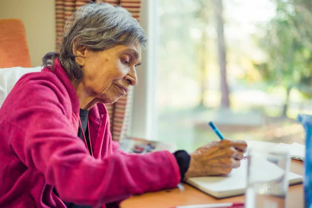 national joy day activities- an elderly woman writing at home