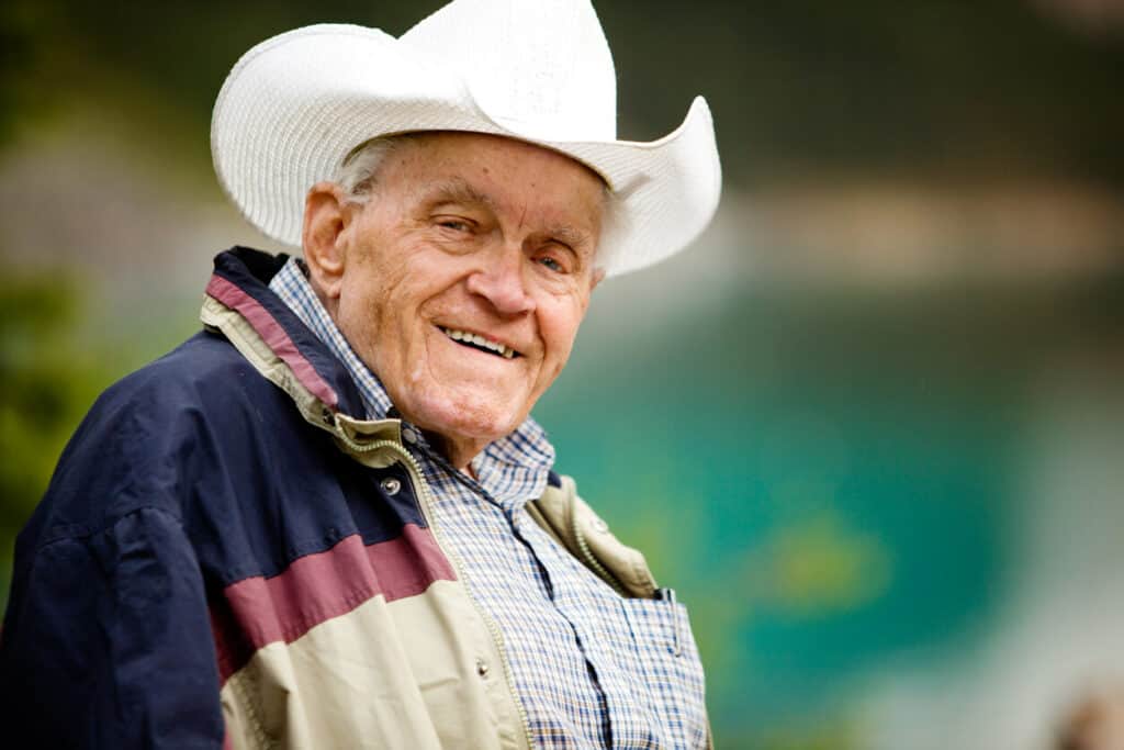 A happy older man wearing a cowboy hat.
