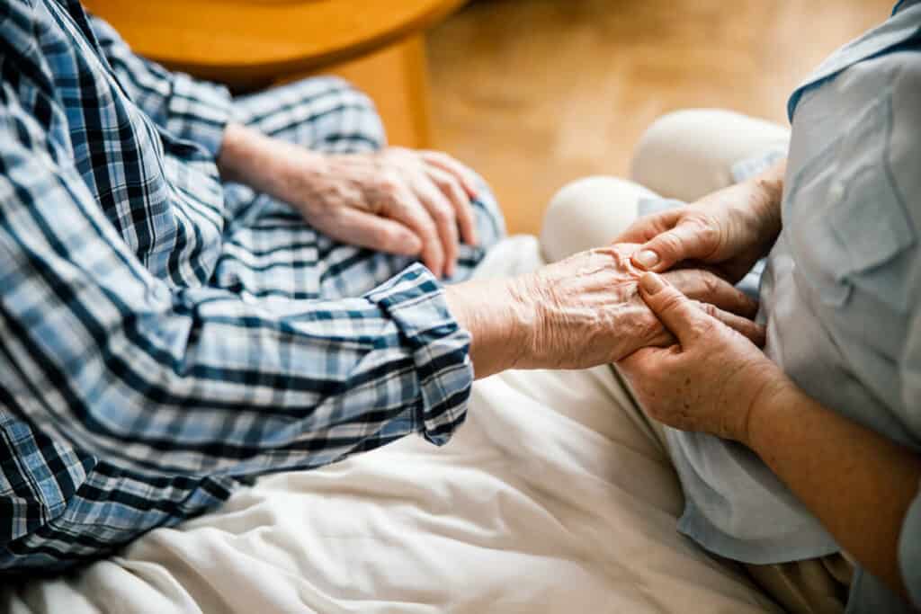 Geriatric massage therapist massaging an elderly’s hands