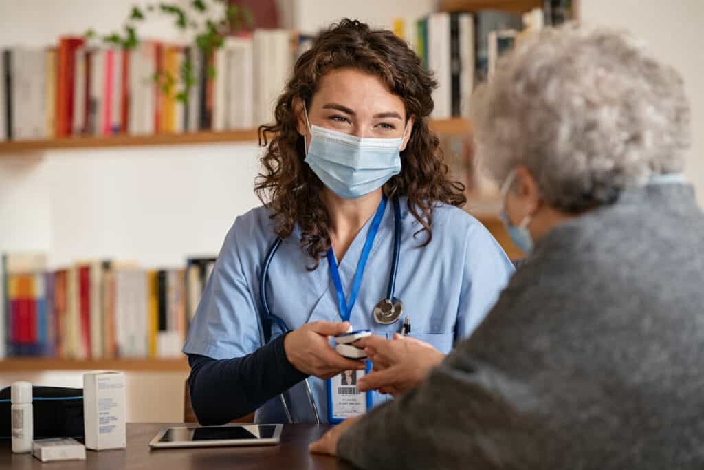Female nursing assistant measuring her elderly client’s oxygen levels