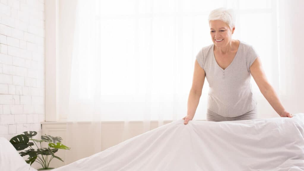 A senior woman changing the bed cover to avoid nonenal or old lady smell.