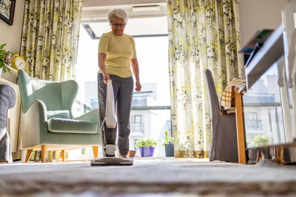 A senior woman cleaning her home to eliminate nonenal odor.