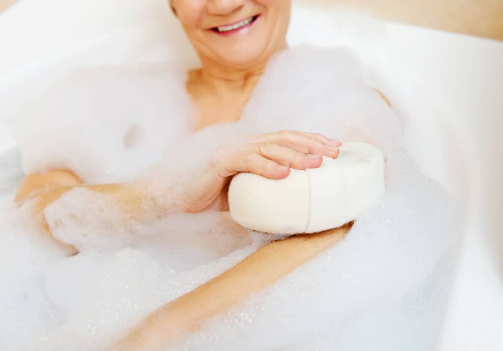 A senior woman taking a bath to remove nonenal odor or old woman smell.
