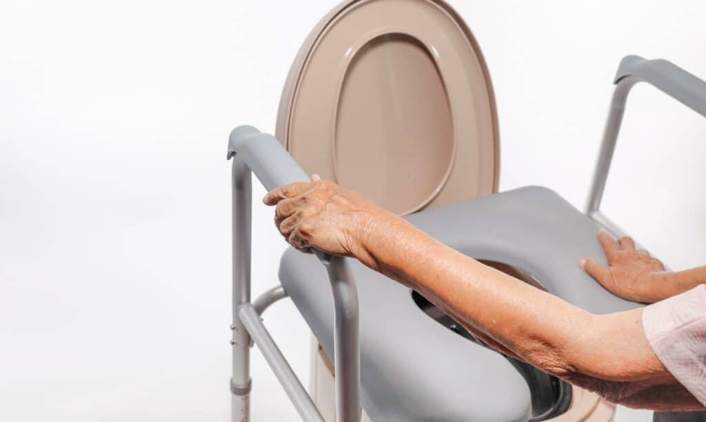 a senior woman using a commode liner in the bathroom ensuring her privacy