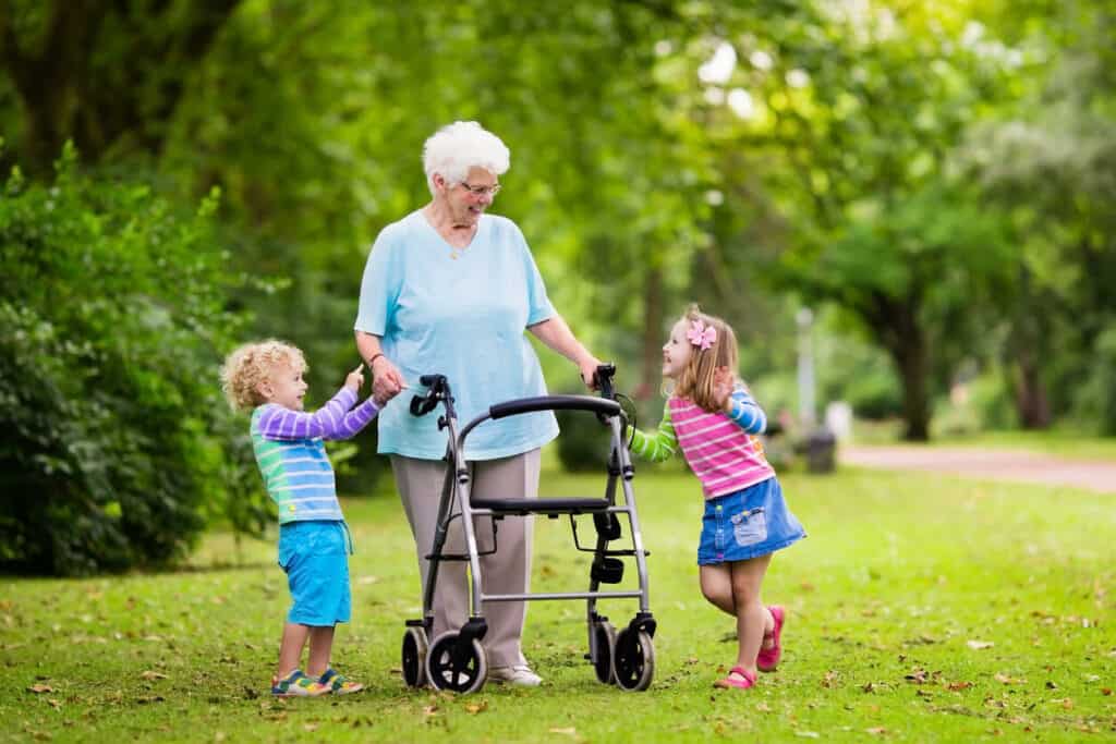 a happy grandmother spending quality time with her granddaughters while utilizing elderly home care equipment