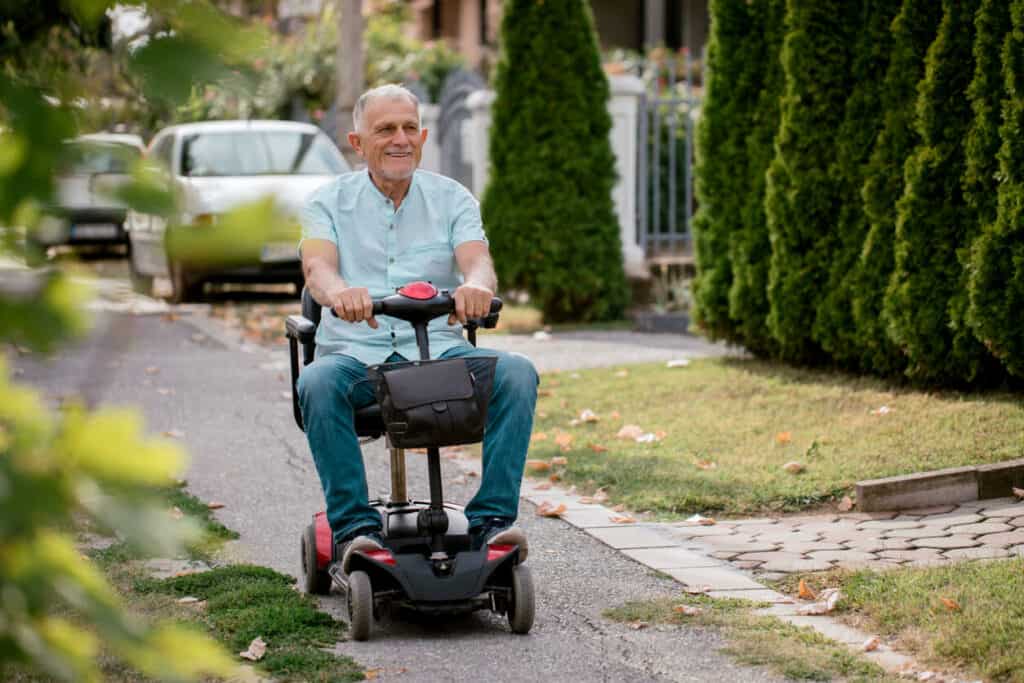 an older adult going home on his power scooter - equipment for seniors
