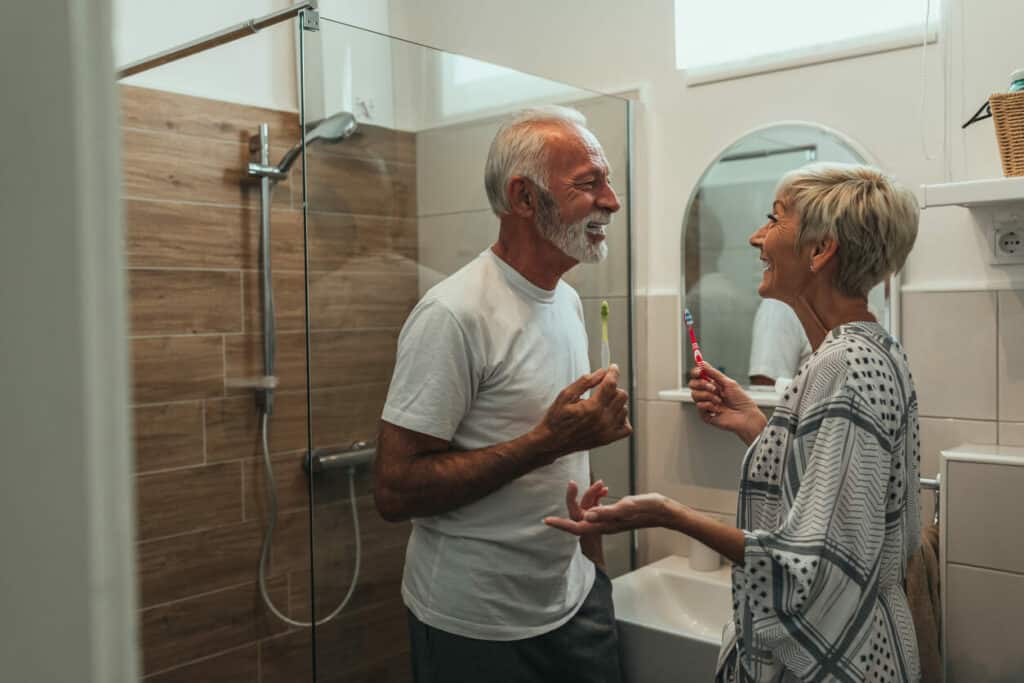 Bathing assistance for elderly - a senior couple brushing their teeth in the bathroom