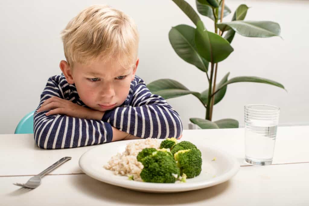 does your taste buds change as you get older - a moody boy staring angrily at a plate with veggies