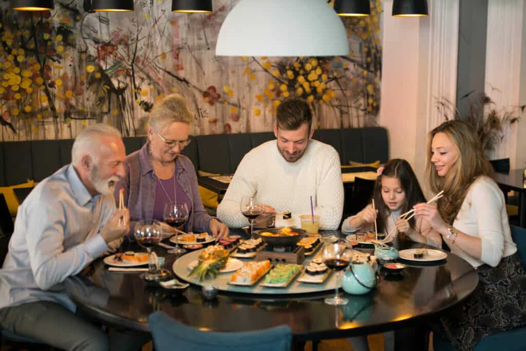 Having meals as socializing events can curb the effects of the taste changes with age | a family of three generations dining at a restaurant