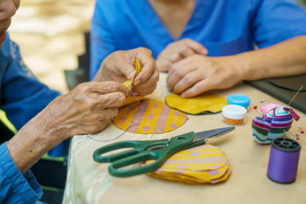 Elderly woman doing needle crafts - occupational therapy seniors
