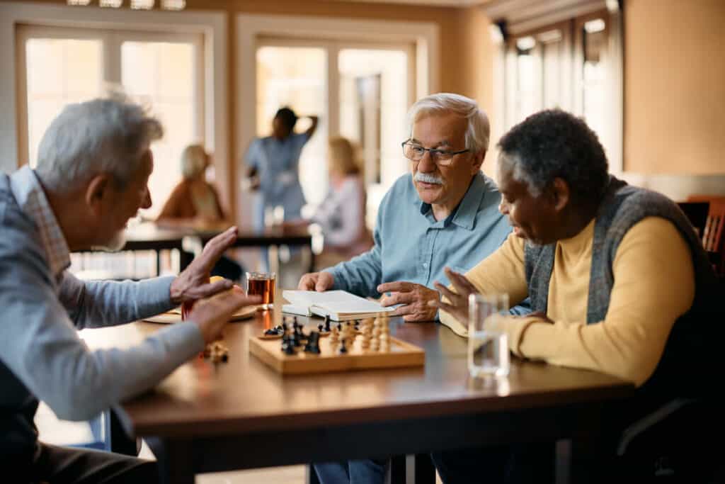 Selfcare for caregivers - senior men playing cheese at an adult daycare center